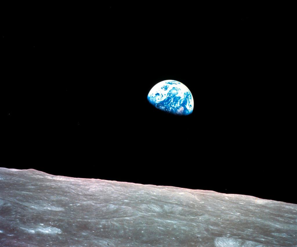 The Earth behind the surface of the moon during the Apollo 8 mission in 1968