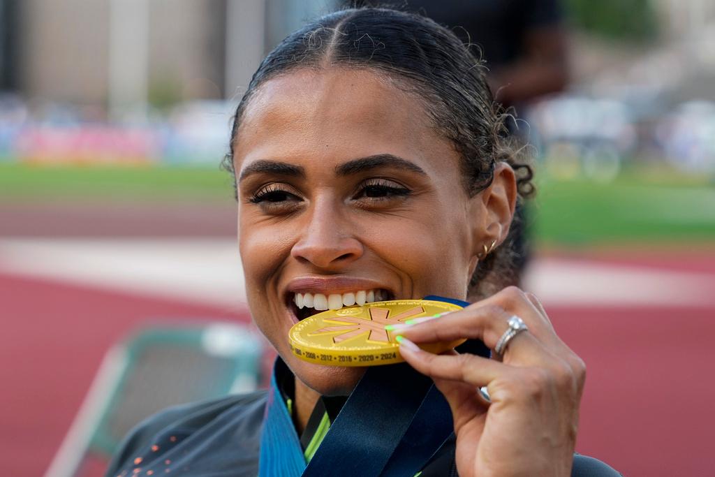 Sydney McLaughlin-Levrone bites down on her gold medal 