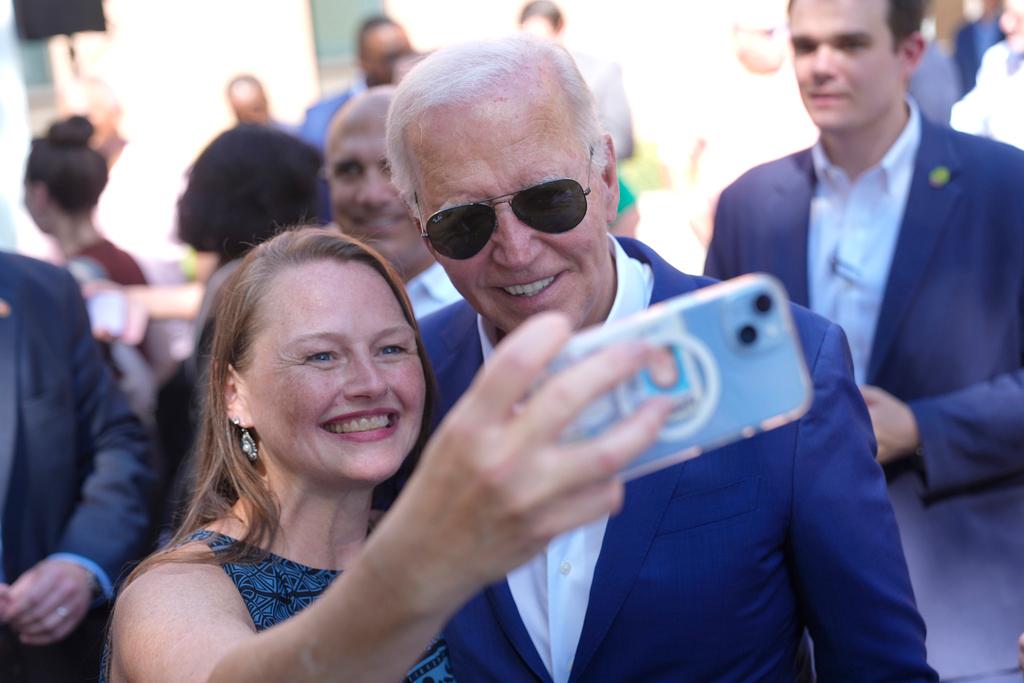 President Joe Biden takes a photo with a supporter at a campaign rally in Harrisburg, Pa.