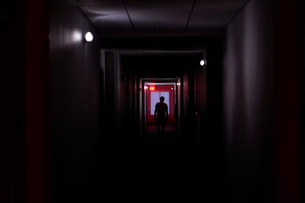 A hotel guest navigates the halls after power was lost due to Hurricane Beryl, Monday, July 8, 2024, in Bay City, Texas. 