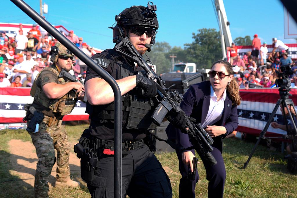 U.S. Secret Service agents respond as Republican presidential candidate former President Donald Trump is surrounded on stage by U.S. Secret Service agents at a campaign rally