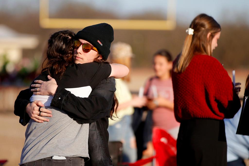 People embrace at a vigil in Tishomingo, Okla. for six high school students who died in a vehicle collision earlier in the week. The crash has the National Transportation Safety Board urging parents to warn teenagers about the risk of driving after using marijuana. 