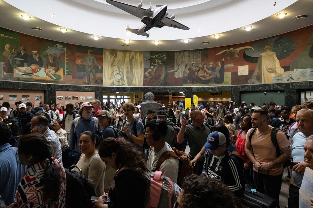Customers wait at a departure area for Spirit Airlines at LaGuardia Airport in New York