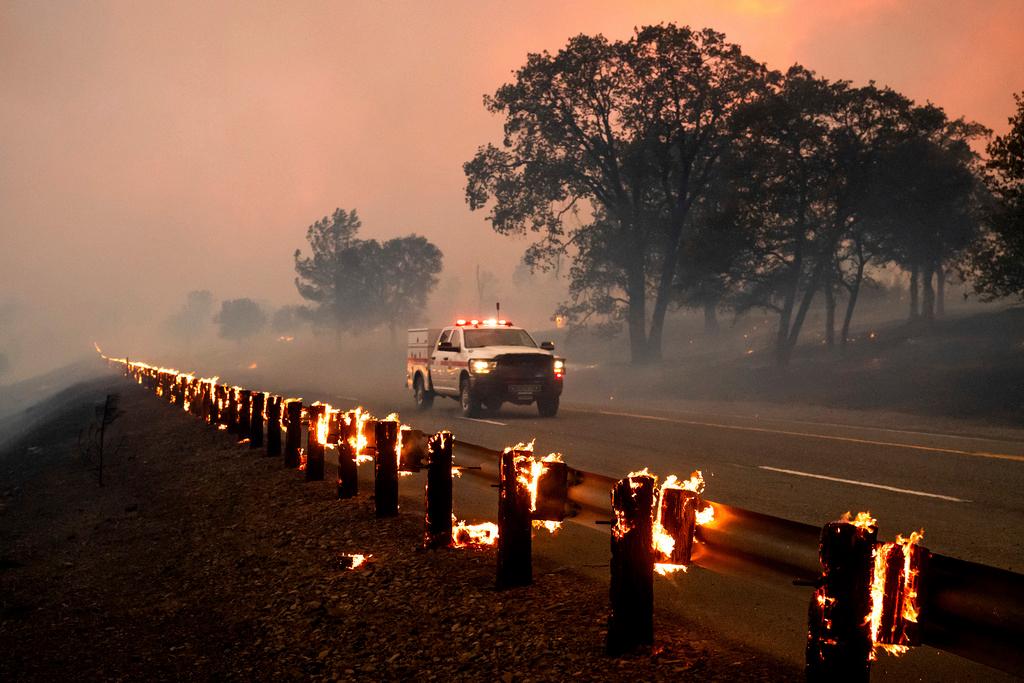 Rail posts burn along Highway 36 as the Park Fire spreads near Paynes Creek in Tehama County, Calif.