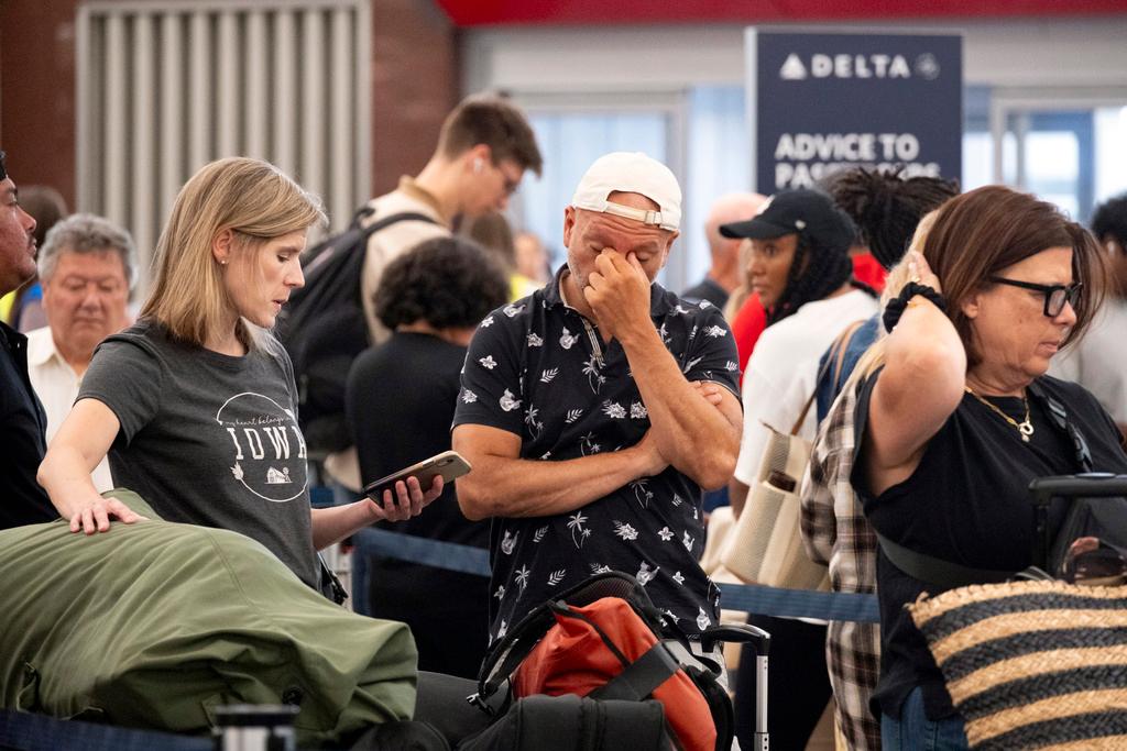 Tiffany McAllister and Andres Bernal try to rebook their flight to Iowa while at Hartsfield Jackson International Airport in Atlanta