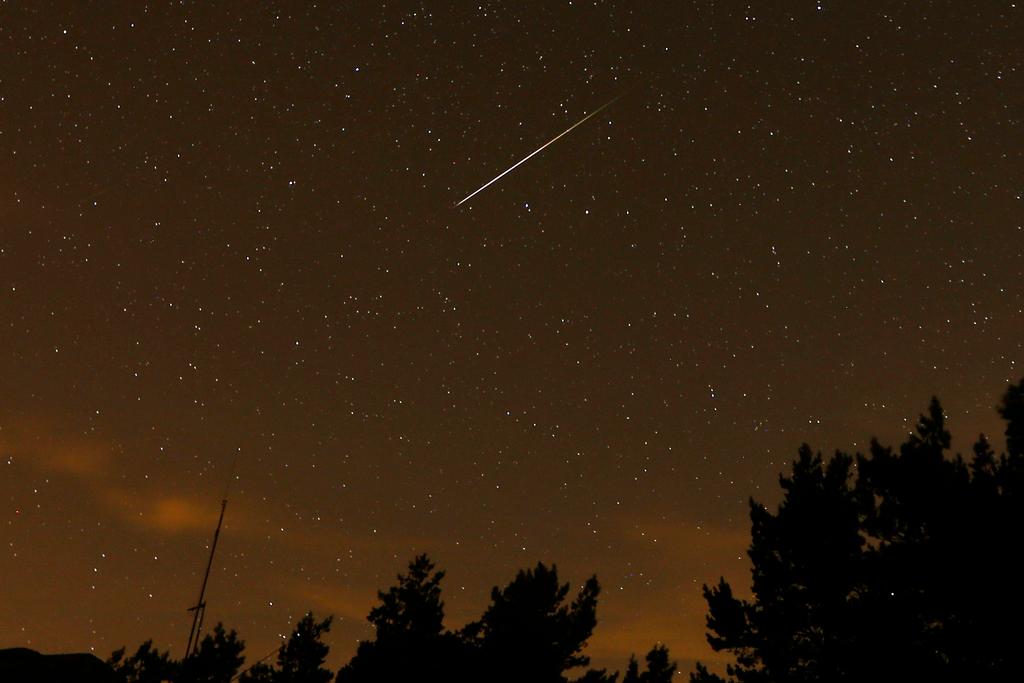 FILE - In this long exposure photo, a streak appears in the sky during the annual Perseid meteor shower at the Guadarrama mountains, near Madrid, in the early hours of Aug. 12, 2016.
