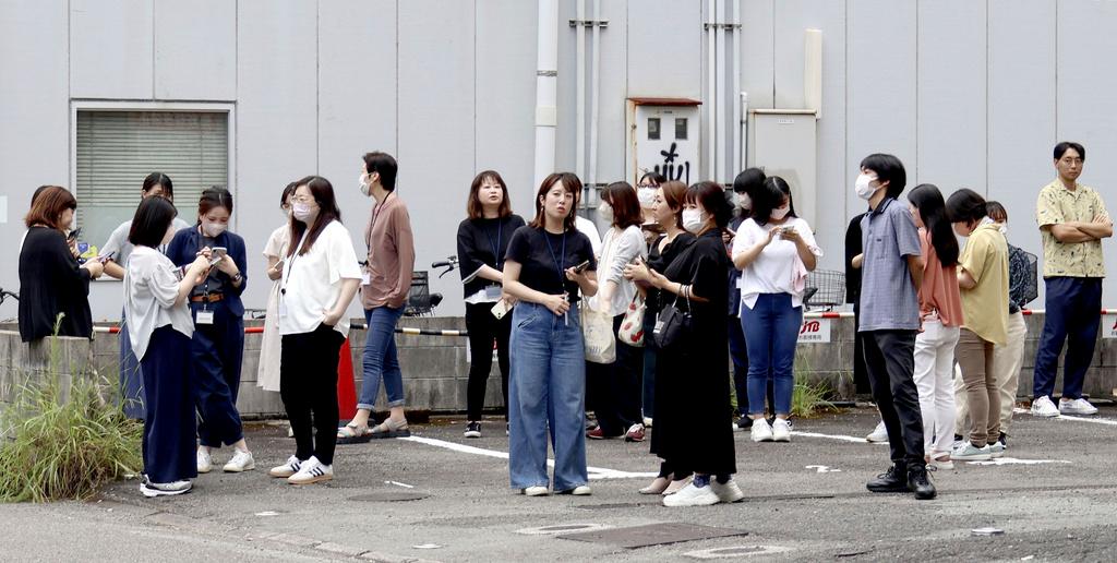 People take shelter outside building following an earthquake in Miyazaki, western Japan, Thursday, Aug. 8, 2024.