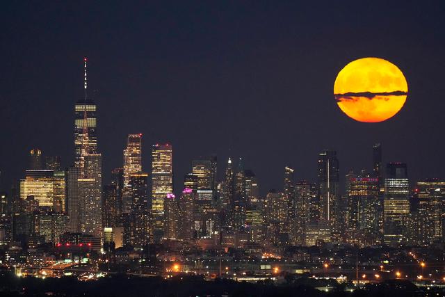 Moon rises through clouds over the skyline of lower Manhattan in this view from West Orange, N.J.