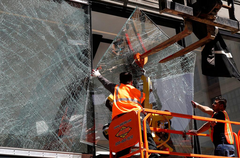 Work crew removes broken windows at a Yves Saint Laurent store in San Francisco