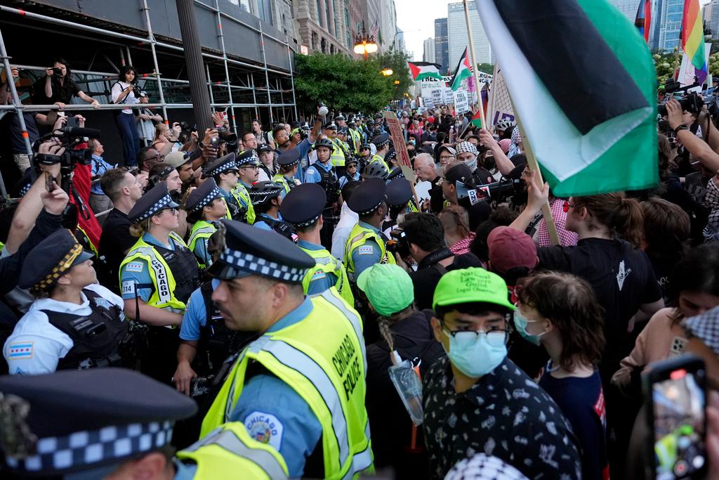 Protesters march passed a police line prior to the start of the Democratic National Convention 
