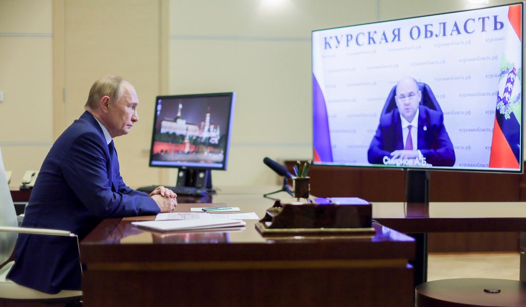 Russian President Vladimir Putin, left, listens to acting Gov. Alexei Smirnov of the Kursk region during a videoconference at Putin’s Novo-Ogaryovo state residence outside Moscow