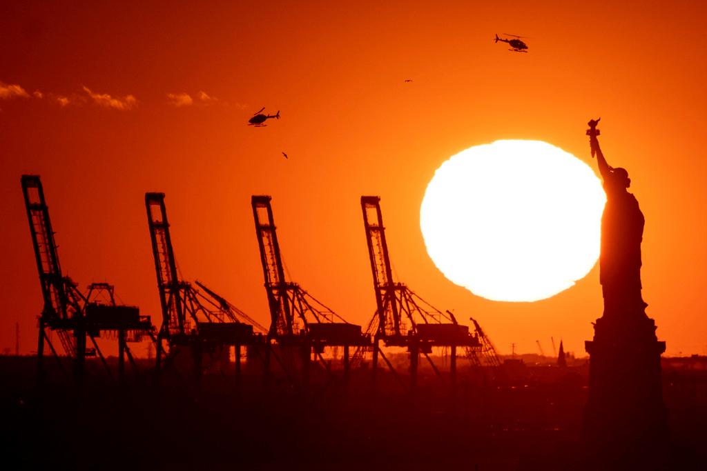Cranes at the Port of New York and New Jersey appear behind the Statue of Liberty