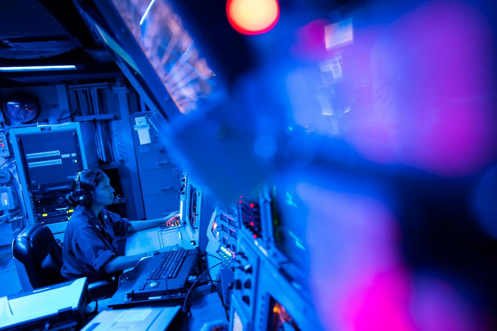 Crew members work in the combat information center of the Arleigh Burke-class guided missile destroyer USS Laboon during a deployment in the Red Sea