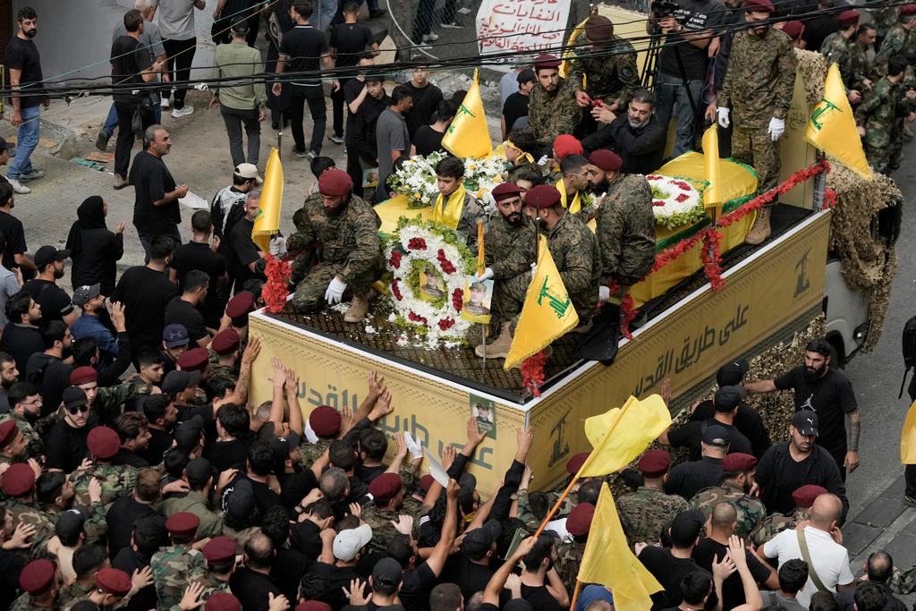 Hezbollah supporters march behind the hearse carrying the coffins of Hezbollah commander Ibrahim Akil and militant Mahmoud Hamad during their funeral procession in Beirut's southern suburb, Sunday, Sept. 22, 2024. 
