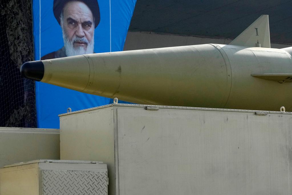 A missile is carried on a truck in front of a portrait of the late Iranian revolutionary founder Ayatollah Khomeini in front of his shrine