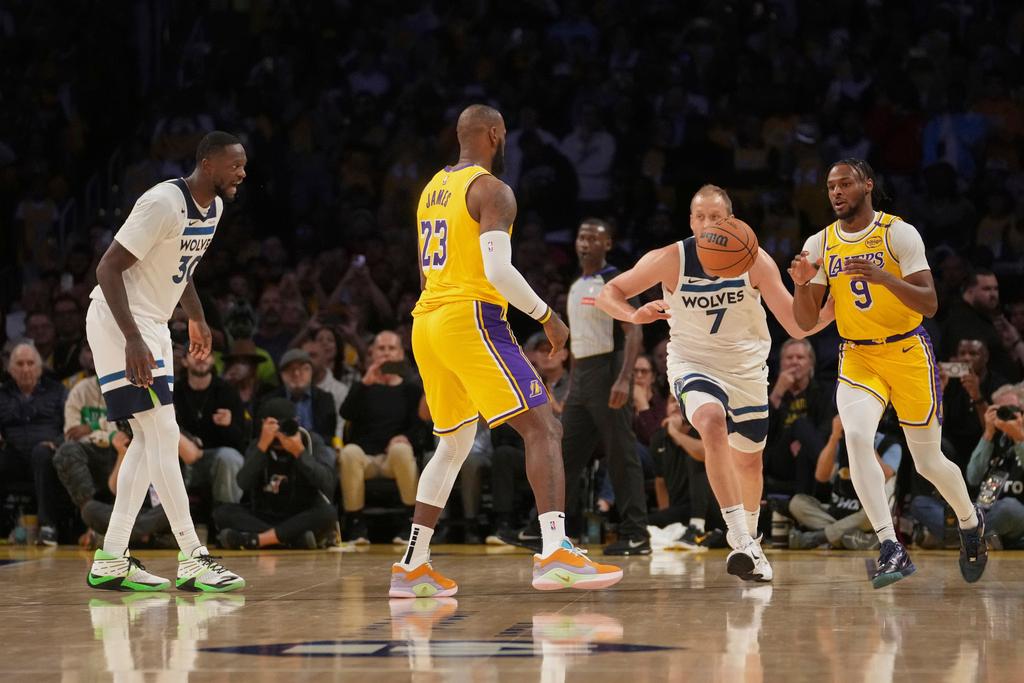 Los Angeles Lakers forward LeBron James (23) looks to pass to guard Bronny James (9) during the first half of an NBA basketball game against the Minnesota Timberwolves, Tuesday, Oct. 22, 2024, in Los Angeles. 