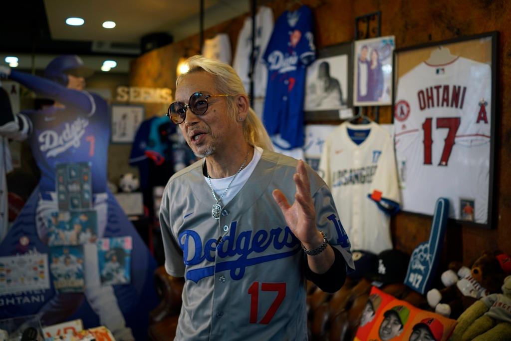 Hironobu Kanno, representative of a private fan club of Shohei Ohtani of the Los Angeles Dodgers, speaks surrounded by his collection goods of Ohtani at his beauty salon in Oshu, northeastern Japan, the hometown of Ohtani, Tuesday, Oct. 29, 2024.