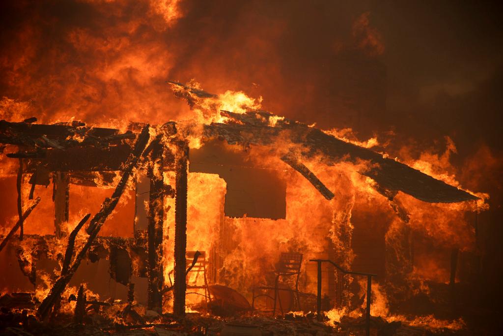 Flames engulf a structure during the Mountain Fire near Camarillo, Calif.