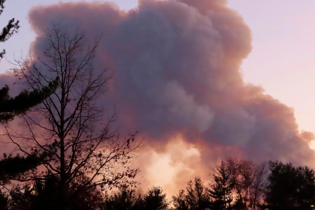 Smoke from a forest fire rises above the trees in Evesham, N.J.