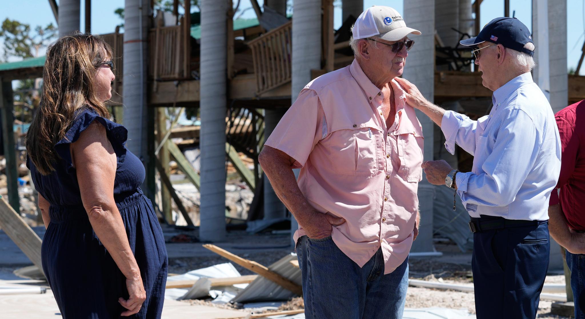 Pres. Biden comforts two people near a disaster