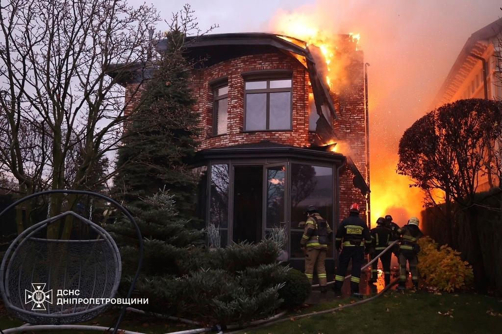 In this photo provided by the Ukrainian Emergency Services on Nov. 21, 2024, rescue workers put out a fire of a burning house damaged by a Russian strike on Dnipro, Ukraine. 
