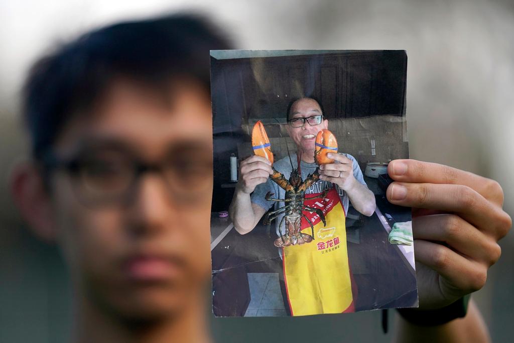 FILE - Harrison Li holds a photo of his father, Kai Li, as he poses for a photo, Jan. 23, 2024, in Palo Alto, Calif. 