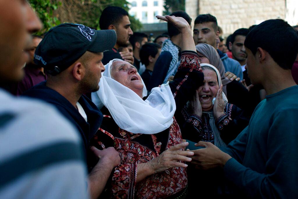 Palestinians pray next to the bodies of their relatives killed in the Israeli bombardment of the Gaza Strip, at a hospital in Deir al-Balah, Sunday, Dec. 15, 2024.