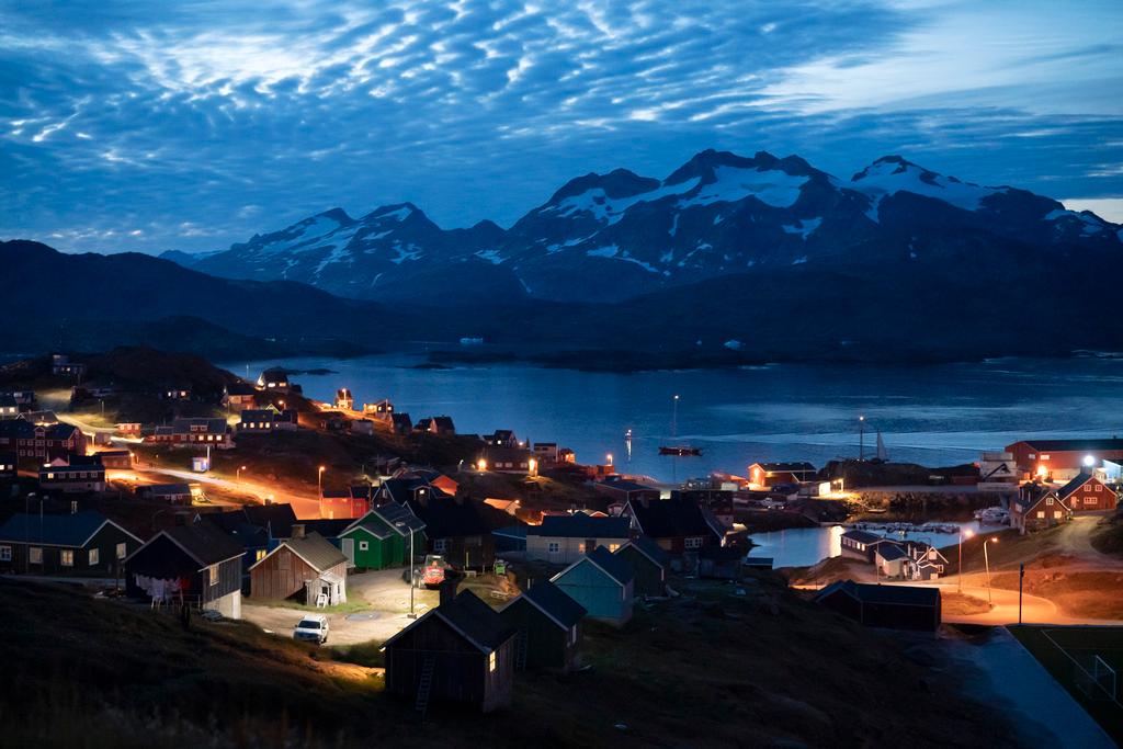 Homes are illuminated after the sunset in Tasiilaq, Greenland