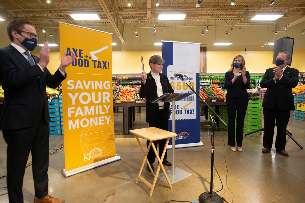 Surrounded by members of the legislature and signs touting saving families money, Kansas Gov. Laura Kelly announces her 'Axe the Food Tax' campaign at Dillons grocery store in Topeka