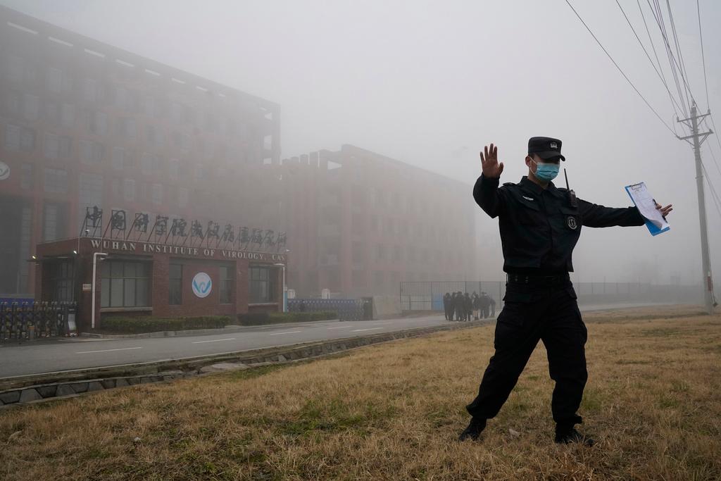 A security person moves journalists away from the Wuhan Institute of Virology after a World Health Organization team arrived for a field visit in Wuhan in China's Hubei province