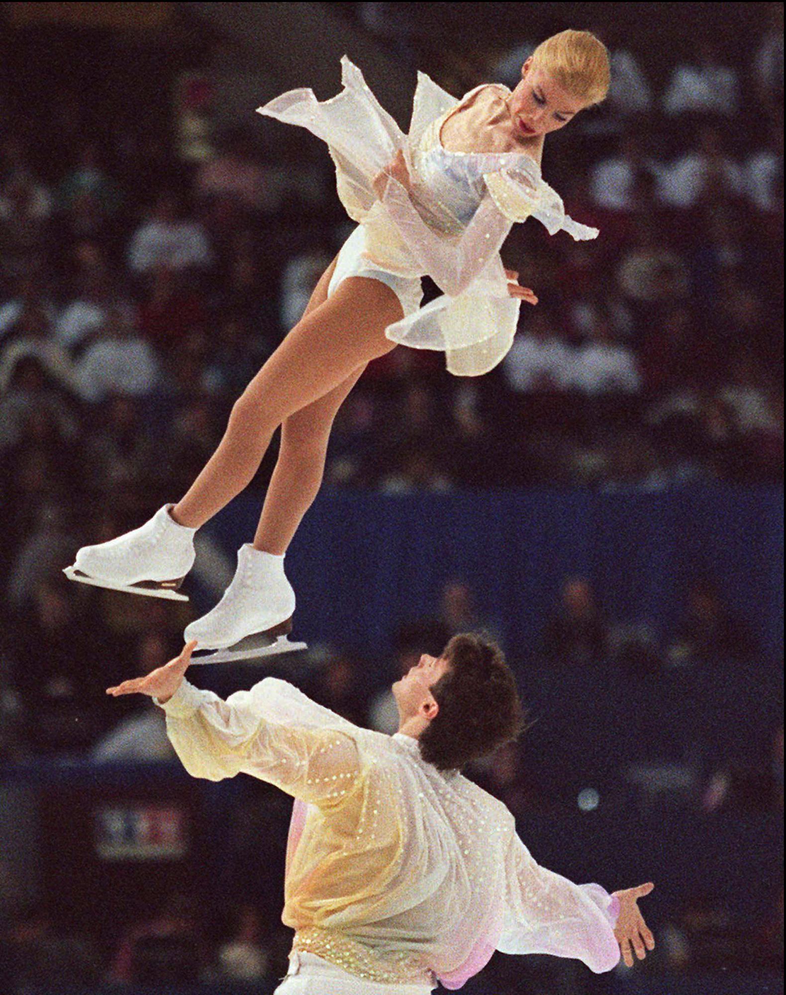 Figure skaters with one female skater mid-air