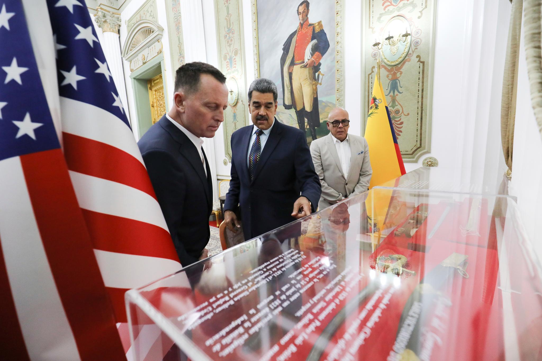 Three men looking at a glass covered case