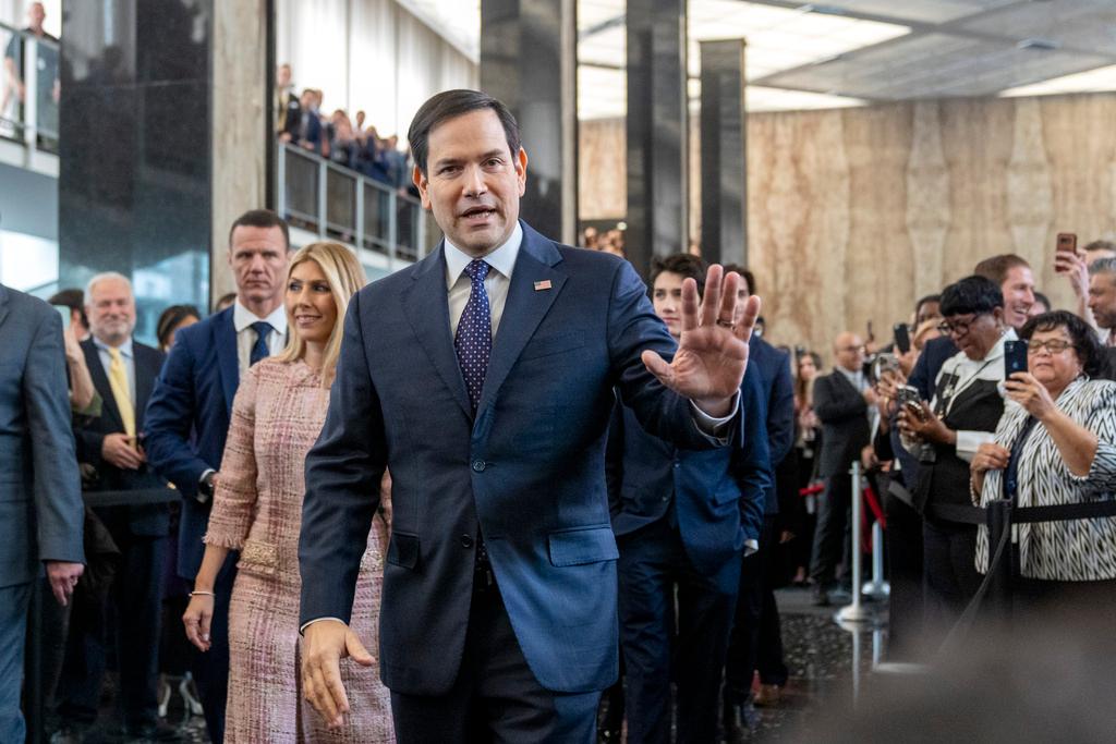 Secretary of State Marco Rubio greets people as he arrives to speak to State Department staff followed by his family