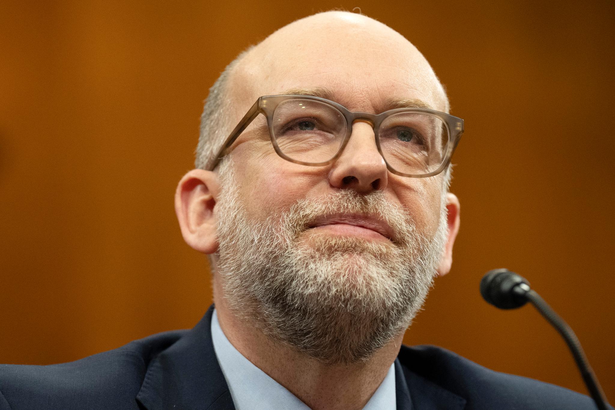 Man with glasses in front of microphone