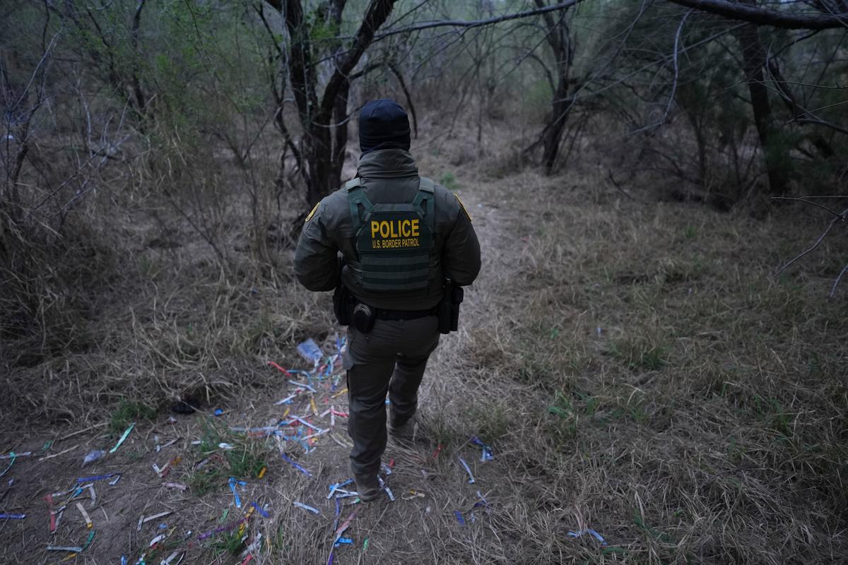 Man walking in a field with human smuggling bracelets on the ground