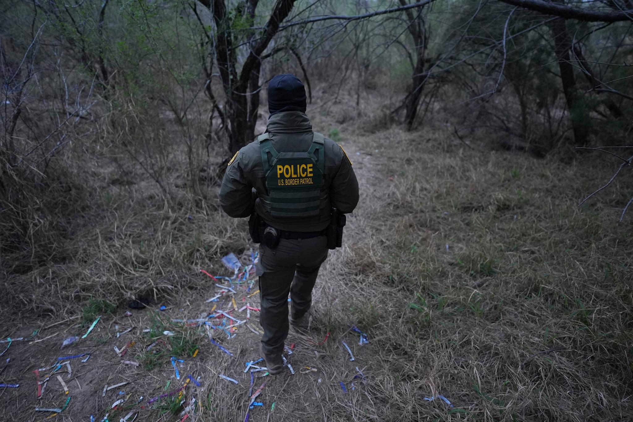 Man walking in a field with human smuggling bracelets on the ground