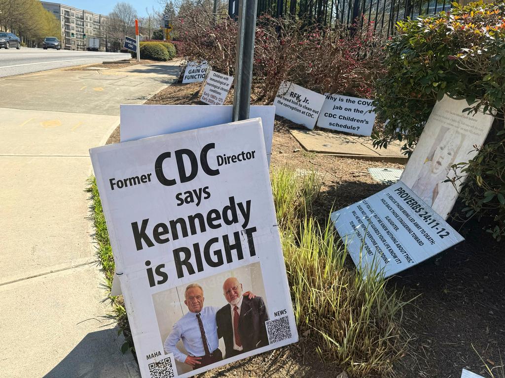 Signs placed by Mike Arnold, a supporter of Health Secretary Robert F. Kennedy Jr., are pictured as Arnold protests against the CDC outside the CDC campus in Atlanta