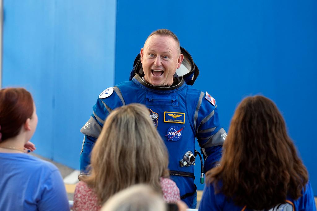 NASA astronaut Butch Wilmore greets his family after leaving the operations and checkout building