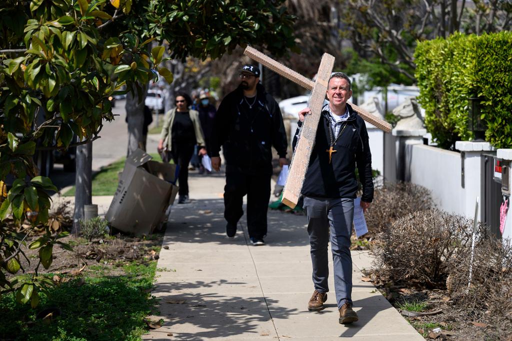 Pastor John Shaver, right, carries a cross during a Cross Walk event by the Community United Methodist Church of the Pacific Palisades