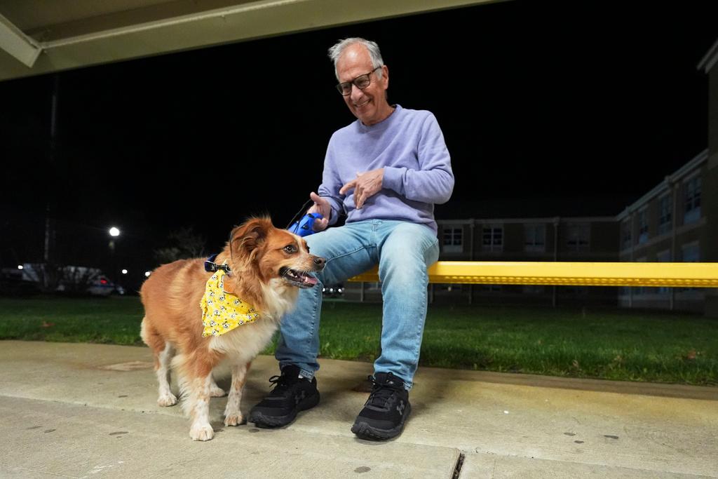 Carmine, of Waretown, and his dog Amber sit outside an evacuation center at Southern Regional High School during wildfires on Tuesday, April 22, 2025, near Stafford Township, N.J. 