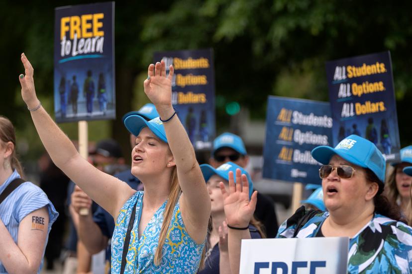 Pamela Smith of Sterling, Va., left, and Tammy-Kay Williams of Fountain Hills, Ariz., supporters of charter schools rally outside of the Supreme Court 