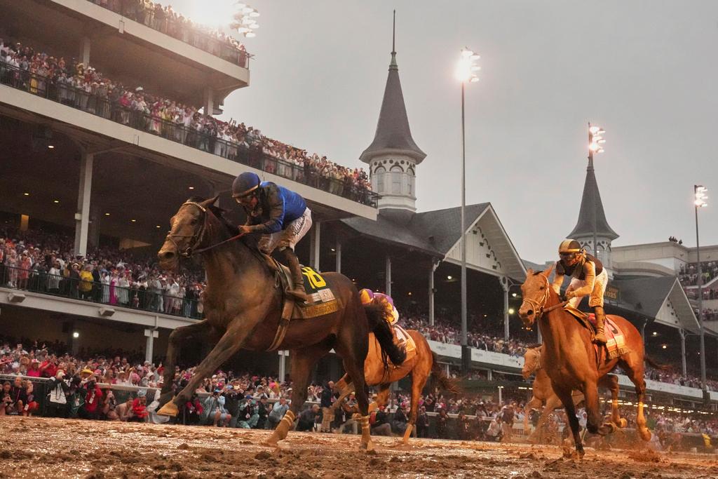 Sovereignty, ridden by Junior Alvarado, left, crosses the finish line to win the 151st running of the Kentucky Derby horse race at Churchill Downs 