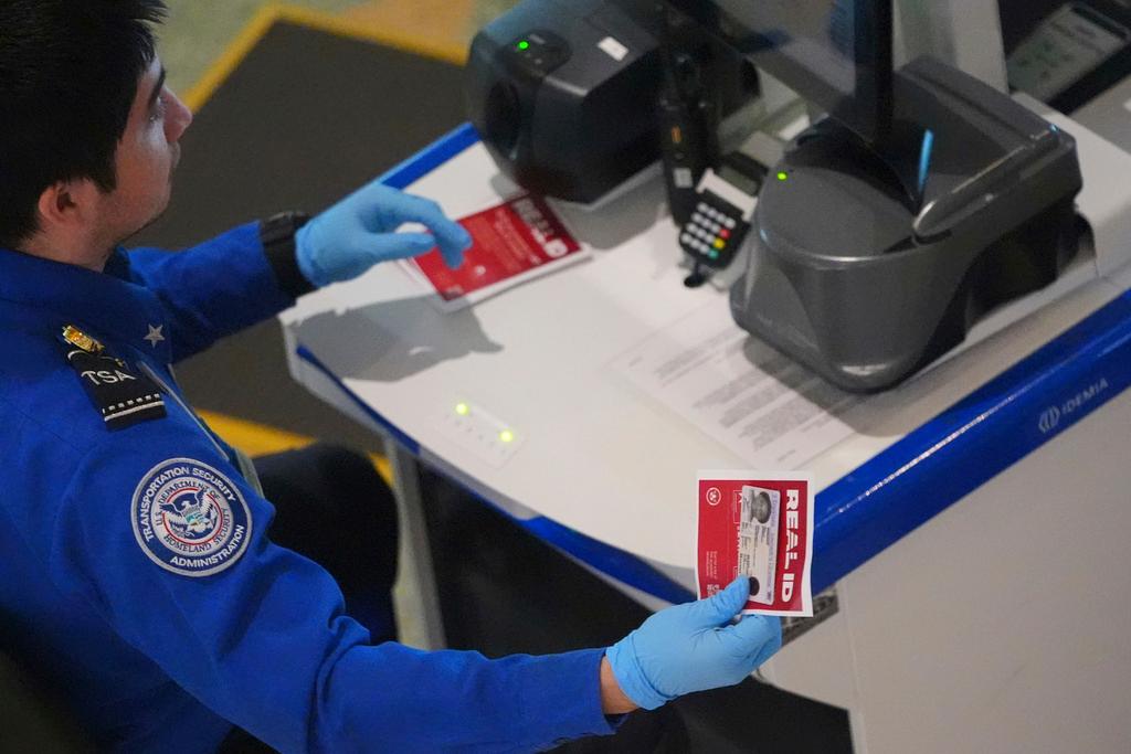 TSA agent hands off a non-Real ID for a traveler passing through security at Love Field airport in Dallas