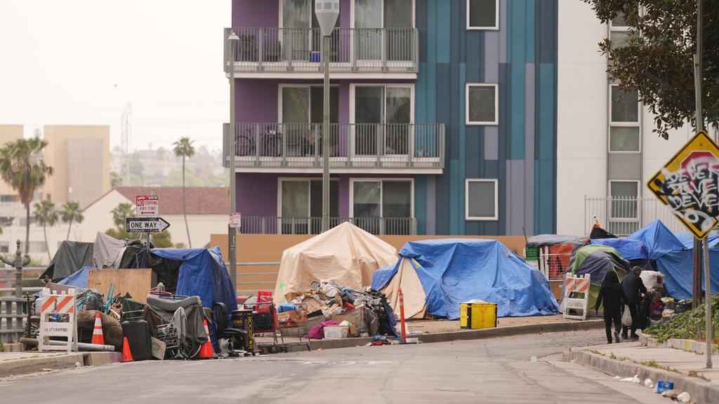Tents are set up along a freeway in a homeless encampment in Los Angeles