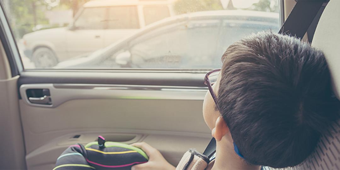 Boy looking outside from car's window