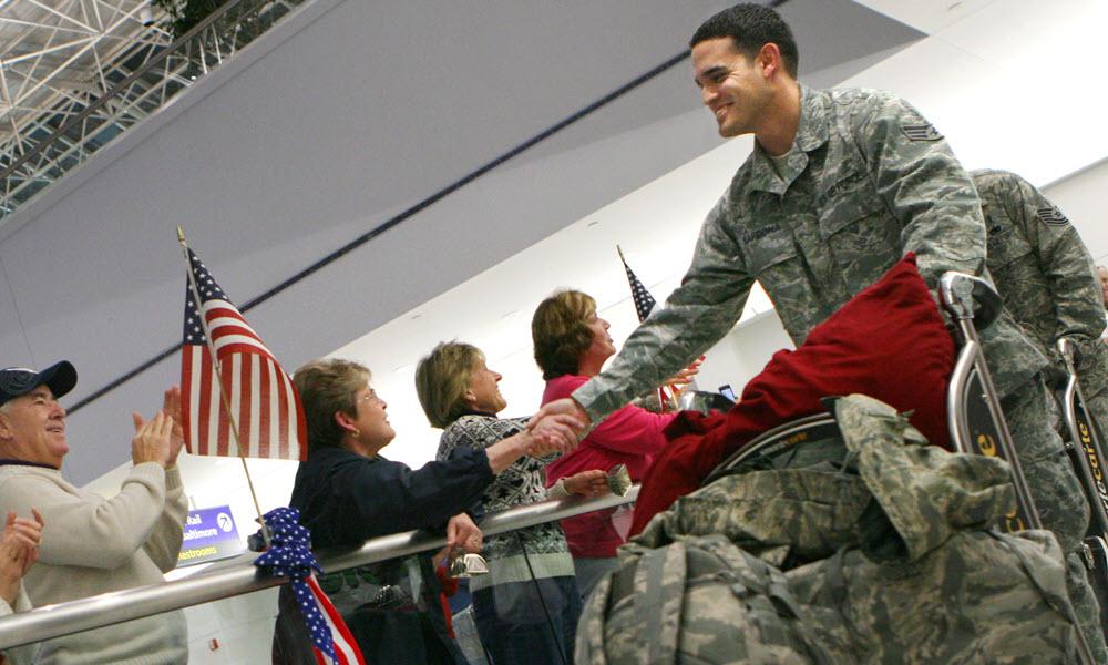 Man in military uniform shaking hands with people