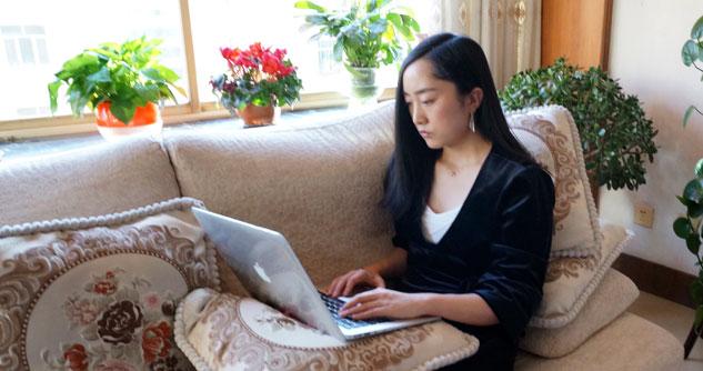 Woman sitting on couch with laptop