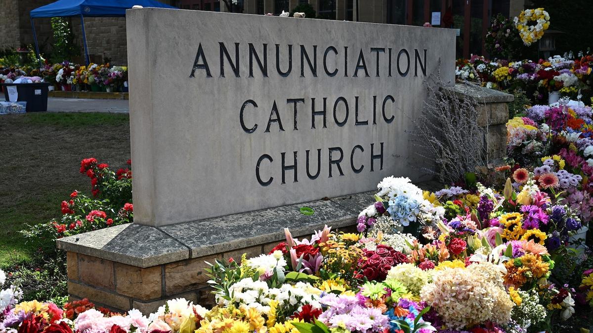 Annunciation Catholic Church sign surrounded by flowers