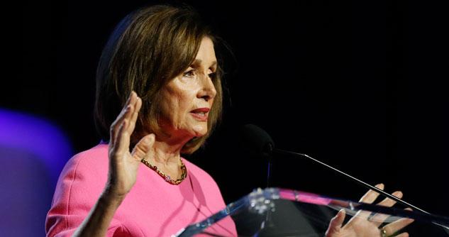 Nancy Pelosi in pink dress with her hands up