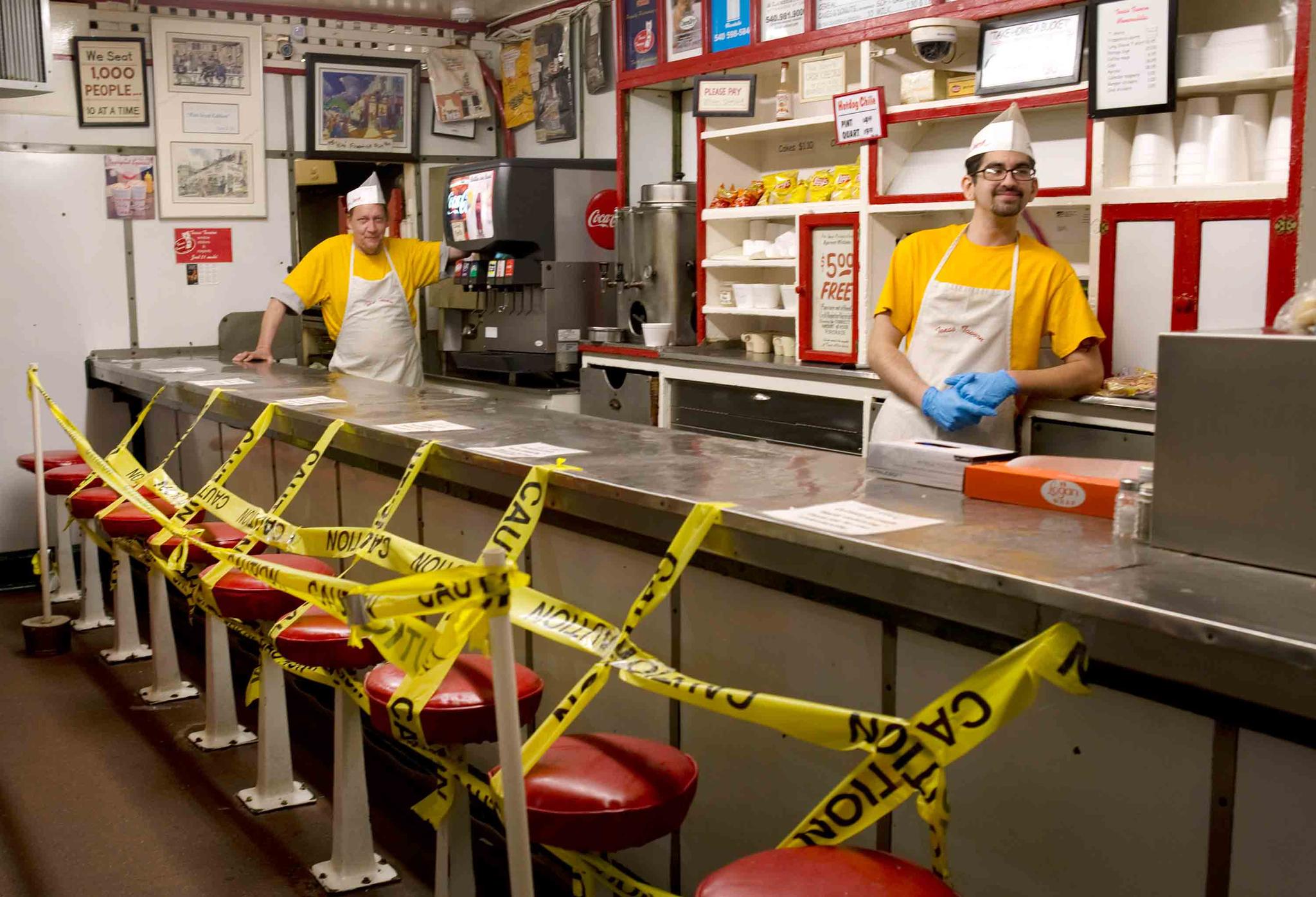 Texas Tavern employees Chris Dobe, left, and Nick Moore wait for take out orders on Monday night, March 30, 2020